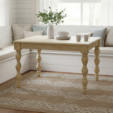 Wooden dining table with decor items in a bright room with white walls and a window.